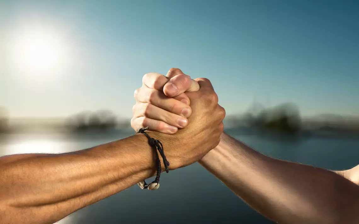 Deux mains serrées symbolisant l'union dans un décor naturelle