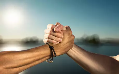 Deux mains serrées symbolisant l'union dans un décor naturelle